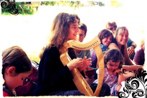A photo from a number of years ago: In a Dragon Storyweaving Circle, Jane and her harp Snowy Owl co-create dragon tales with families in Forest Halls.